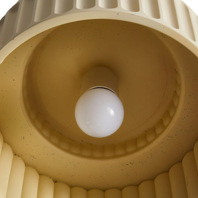 "A close-up view of a ceiling light with a round bulb in the center, surrounded by a ribbed, dome-shaped shade."