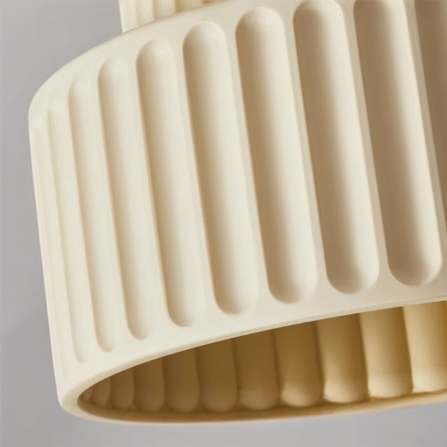 "A close-up of a beige ceiling light with a ribbed, cylindrical shade showing the texture and detail."