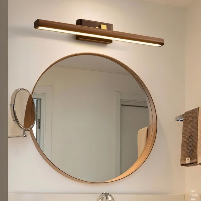 "A modern copper and walnut wall lamp with a linear design, mounted above a round mirror in a contemporary bathroom with a minimalist aesthetic."