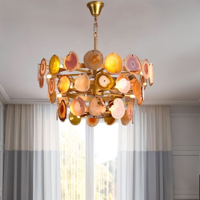 "Gold metal Zylan chandelier with layered circular design and warm-toned agate slices, hanging in a room with sheer curtains."