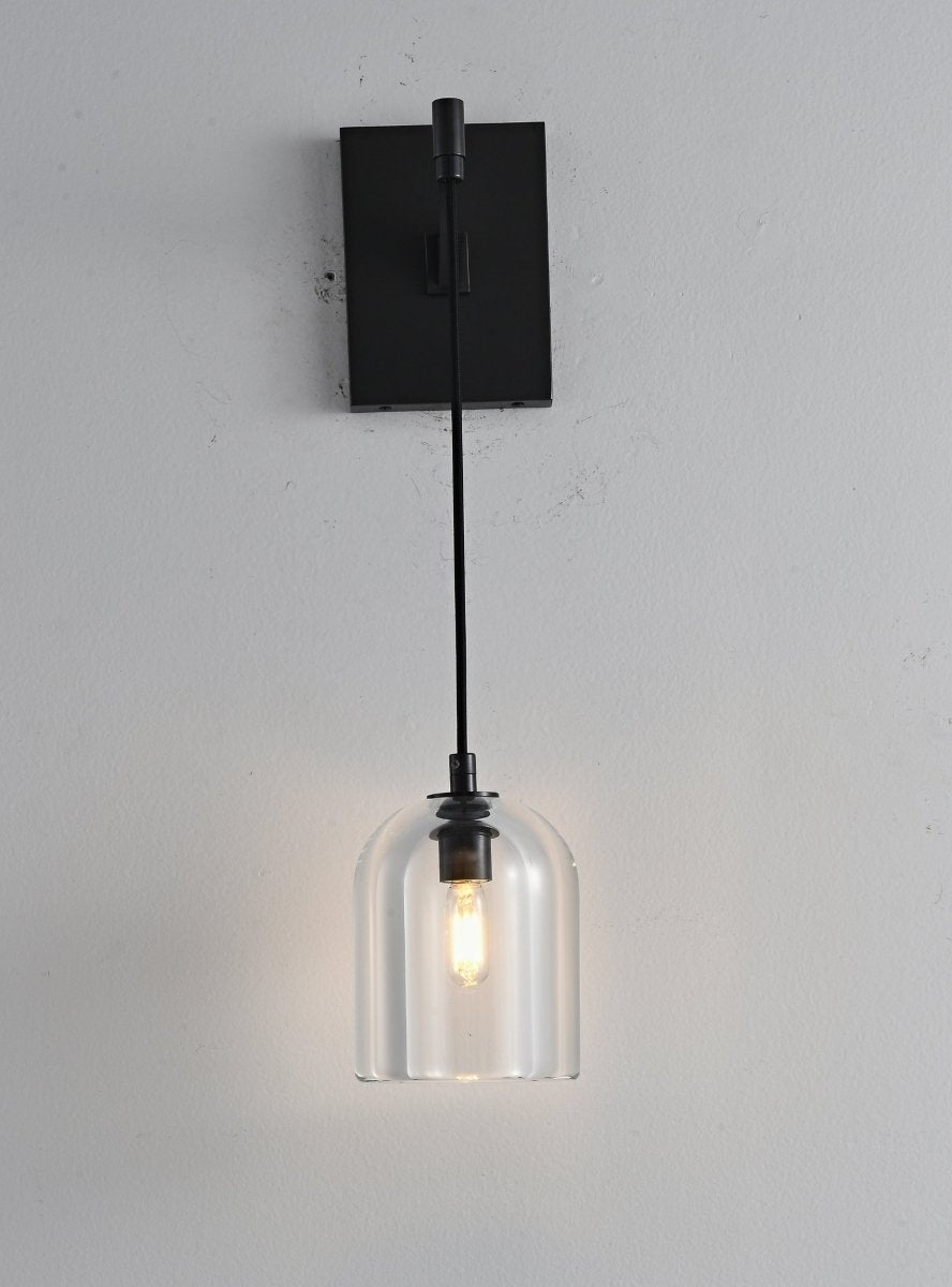 "A modern black wall lamp with a dome-shaped clear glass shade, blending elegance and minimalist design with a curved arm and rectangular base."