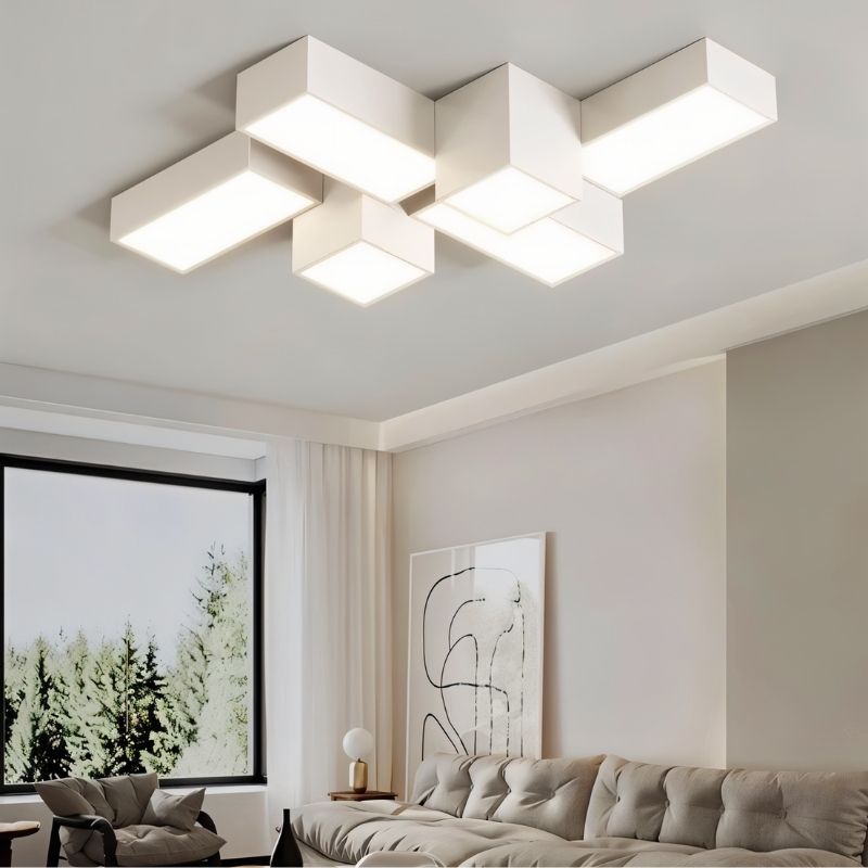 "A large geometric ceiling light with multiple interlocking rectangular forms, illuminating a contemporary living room with diffused light."