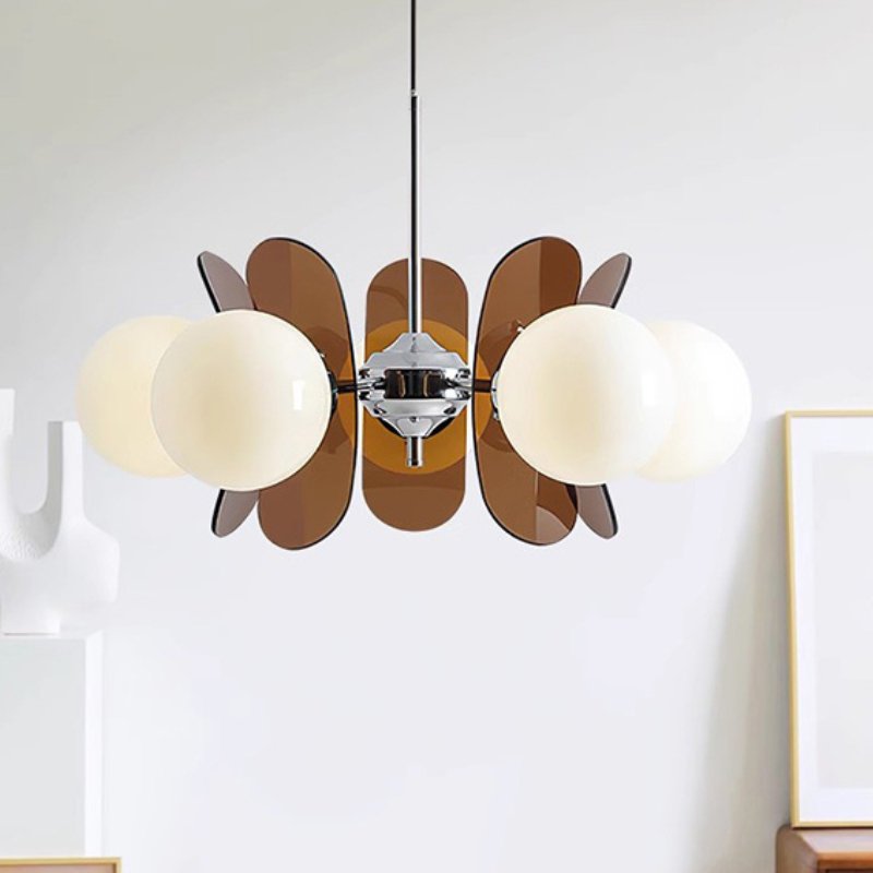 Mid-century modern chandelier with amber glass petals and frosted white globe shades hanging against a white wall.