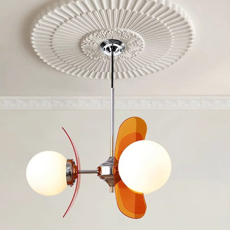 Modern chandelier with chrome finish, two frosted globe shades, and orange glass accents suspended from decorative ceiling medallion.