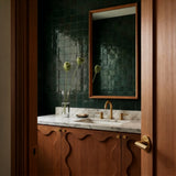 Gatsby Door Handle in Satin Brass, installed in a bathroom