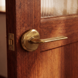 Enzo Door Handle in Satin Brass, on a plain background