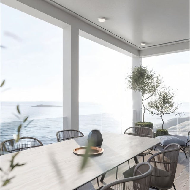 "Contemporary dining area with a sleek aluminum ceiling light, offering functional lighting and a minimalist design that complements modern interiors."