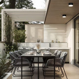 "Aluminum ceiling light above an elegant dining table, providing soft illumination with a modern, cylindrical flush-mount design in a stylish, contemporary space."