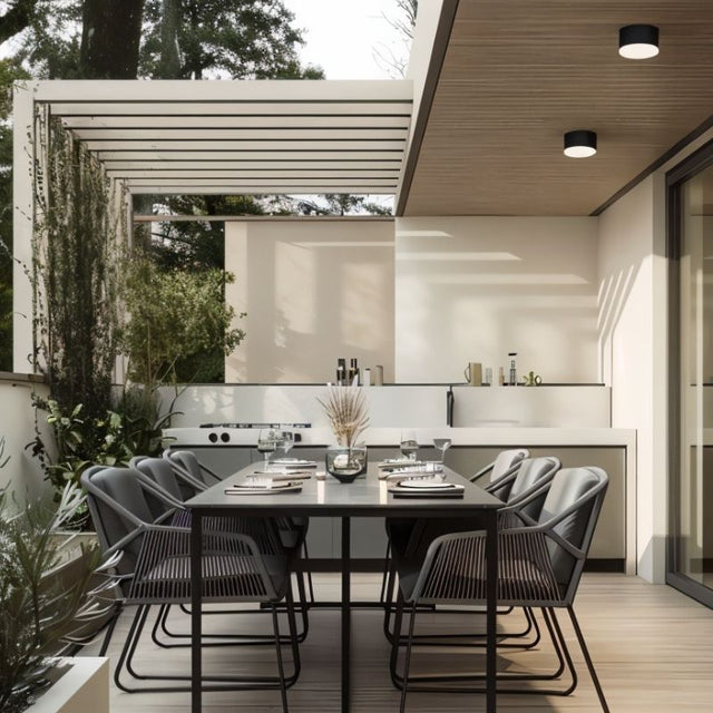 "Aluminum ceiling light above an elegant dining table, providing soft illumination with a modern, cylindrical flush-mount design in a stylish, contemporary space."