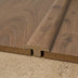 Wood flooring transition piece, featuring a curved top and a wood-like finish, positioned over a textured surface.