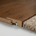 Close-up of seamless wood flooring with a natural finish transitioning to plush beige carpet, showcasing joint details.