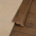 Quarter round transition piece in a wood finish, connecting light textured surface to dark wood flooring.