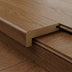 Close-up of a wooden floor plank with a flat edge and a textured finish, showcasing a smooth transition between pieces.