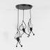 Black multi-pendant chandelier with three dangling cord-suspended lights featuring frosted globe shades, mounted on white background.