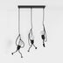 Three-light black pendant fixture with articulated wire legs and frosted glass globes, hanging against white background.