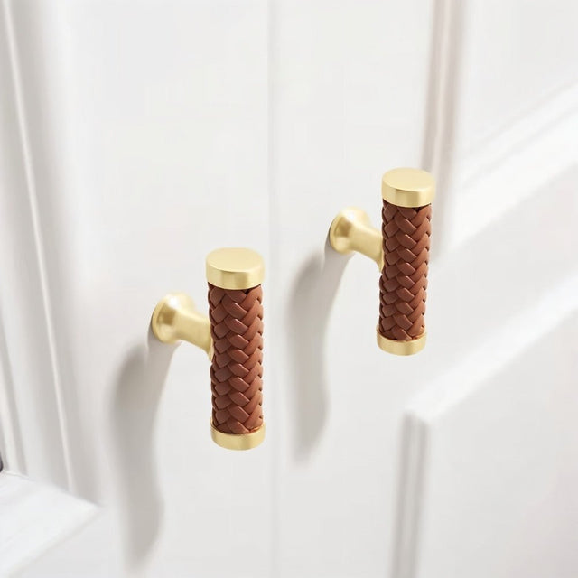 "Pair of braided leather knobs with a luxurious finish on white shaker-style doors."