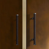 "Pair of braided leather pull bar handles with a luxurious finish on a modern brown wardrobe."