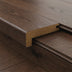 Close-up of a brown wood plank with a gold edge trim, showcasing a smooth finish and distinct corner design.