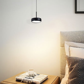 "Black aluminum pendant light illuminating bedroom, cozy ambiance, soft focused lighting"