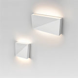 "closeup of white geometric wall lamp, sleek aluminum material, minimalist lighting fixture, ambient illumination"