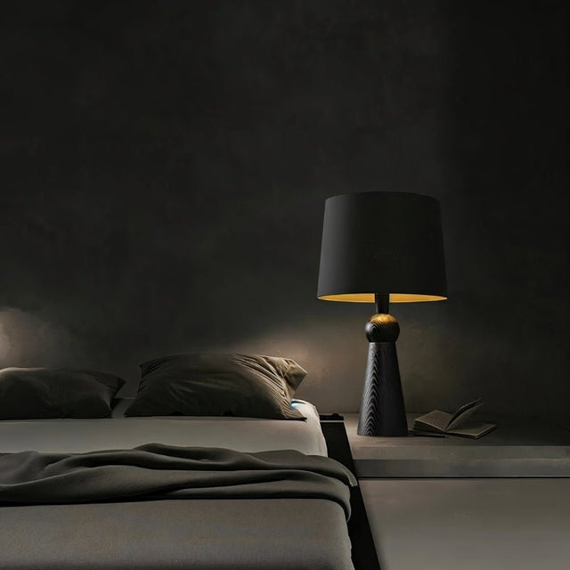 "Stylish bedside table lamp with wooden base and fabric shade, providing soft lighting in a cozy bedroom, made with durable wood and fabric."