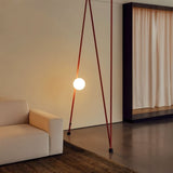 "minimalist lamp with cloth-covered frame and glowing glass orb, installed in modern living room"