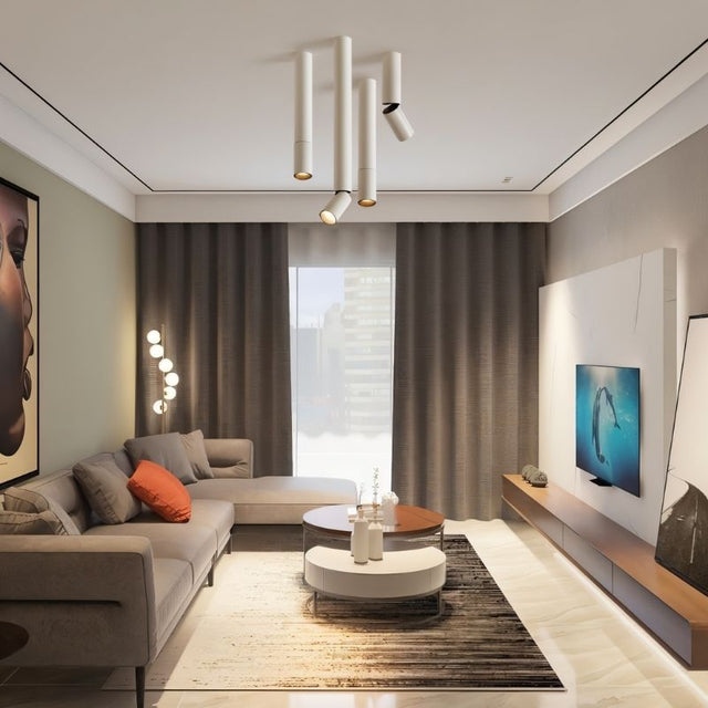 "Minimalist aluminum ceiling light with sleek cylindrical heads providing directional lighting in a living room"
