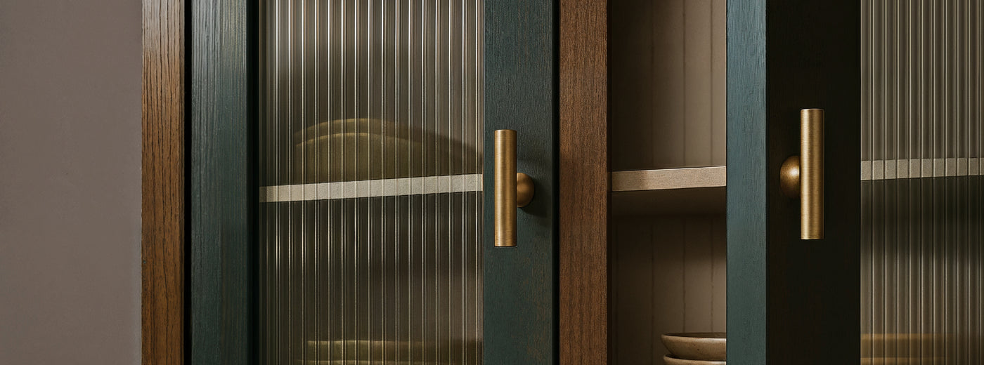 Cabinet with glass doors and Liam brass knobs on a neutral background