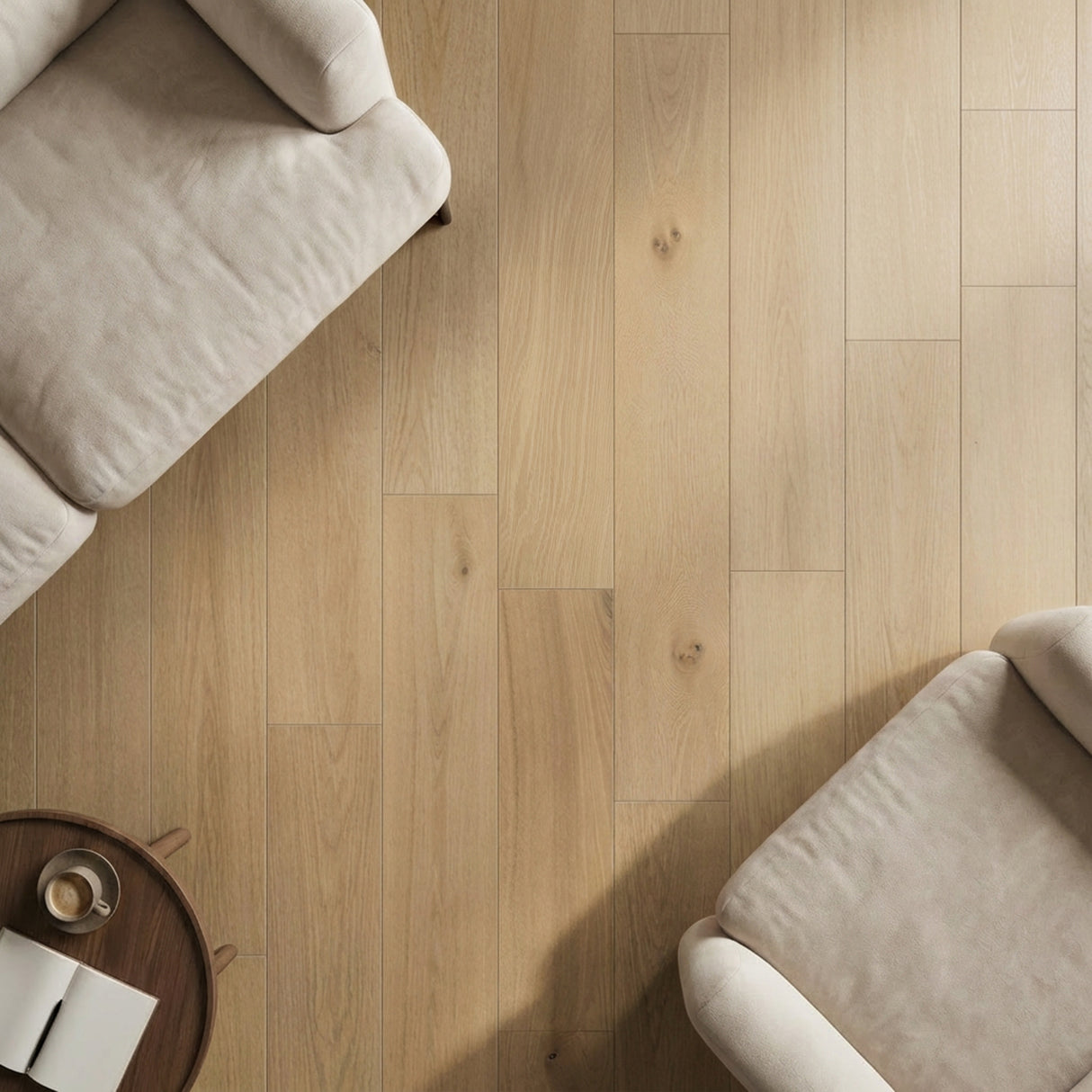 Light oak wood plank flooring with natural grain, displayed in a bright room with cream upholstered furniture.