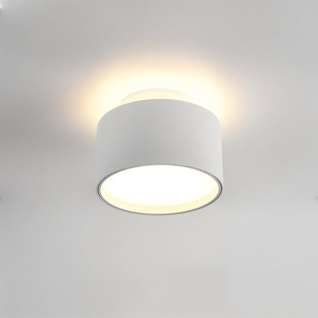 "Closeup of a white aluminum ceiling light with ambient glow, drum-shaped modern design."