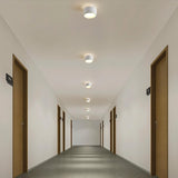 "White aluminum ceiling lights illuminating a long hallway, modern design with ambient lighting."