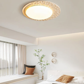 "Ceiling lamp with travertine frame and marble diffuser, illuminating a cozy bedroom interior with soft light."