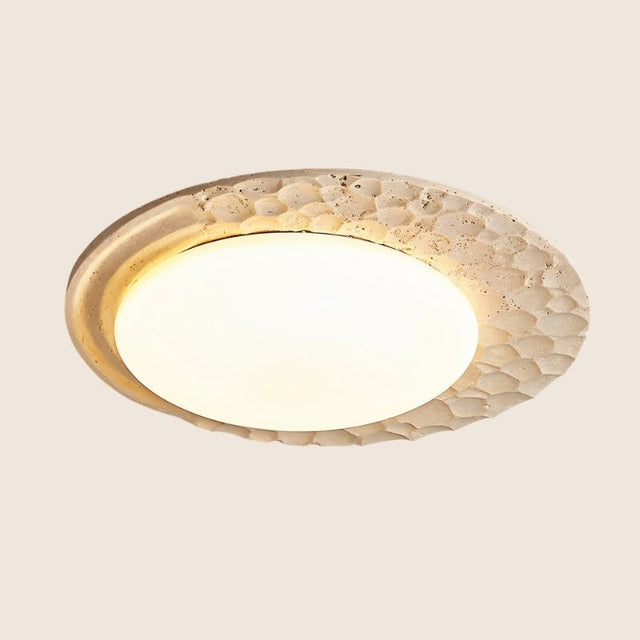 "Close-up view of the ceiling lamp showcasing its textured travertine frame and smooth marble diffuser."
