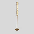 "Close-up view of the Lyris floor lamp with a gold metal base and translucent glass orbs, creating a luxurious and contemporary lighting solution. Crafted from metal, glass, and acrylic."