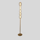 "Close-up view of the Lyris floor lamp with a gold metal base and translucent glass orbs, creating a luxurious and contemporary lighting solution. Crafted from metal, glass, and acrylic."