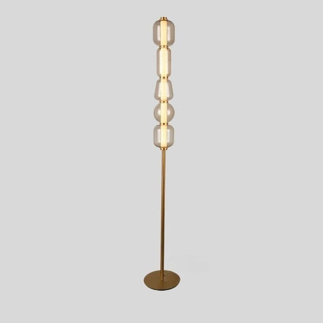 "Close-up view of the Lyris floor lamp with a gold metal base and translucent glass orbs, creating a luxurious and contemporary lighting solution. Crafted from metal, glass, and acrylic."