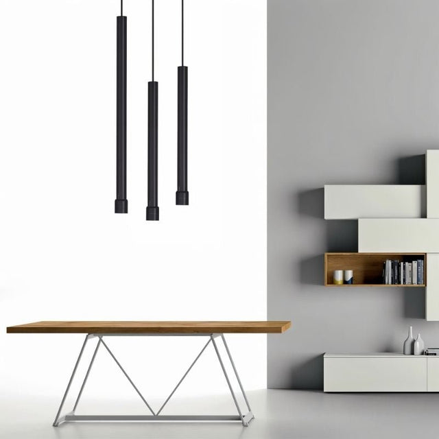 "Three black pendant lights above wooden dining table, modern minimalist interior setting"