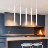 "White cylindrical pendant lights in modern kitchen, creating clean ambient and task lighting"