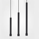 "Three sleek cylindrical aluminum pendant lights, black finish, suspended with linear cords"