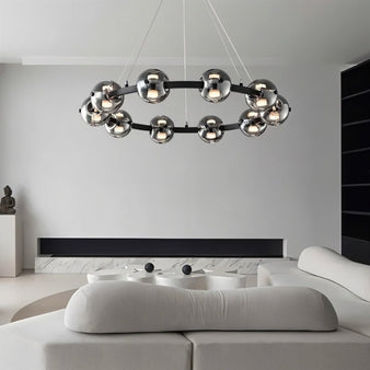 "Sleek chandelier with smoked glass orbs above a modern sofa in a living room ambiance."