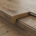 Close-up of a brown wooden floor transition piece with a smooth edge, fitting into matching planks.