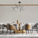 "Modern chandelier with geometric design, featuring several angular arms and LED light sources, providing a stylish, contemporary look in a dining area."