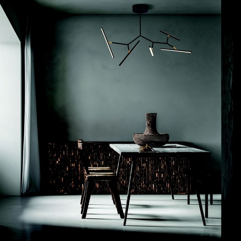 "Chandelier with artistic design in a moody room, featuring angular black arms and bright LED lights, ideal for modern interiors."