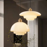 "Two Niall pendant lights with layered metal and glass design, offering a warm glow, ideal for modern interiors."
