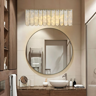 "Bathroom wall lamp with shell panels and metal frame, placed above a round mirror and vanity sink."