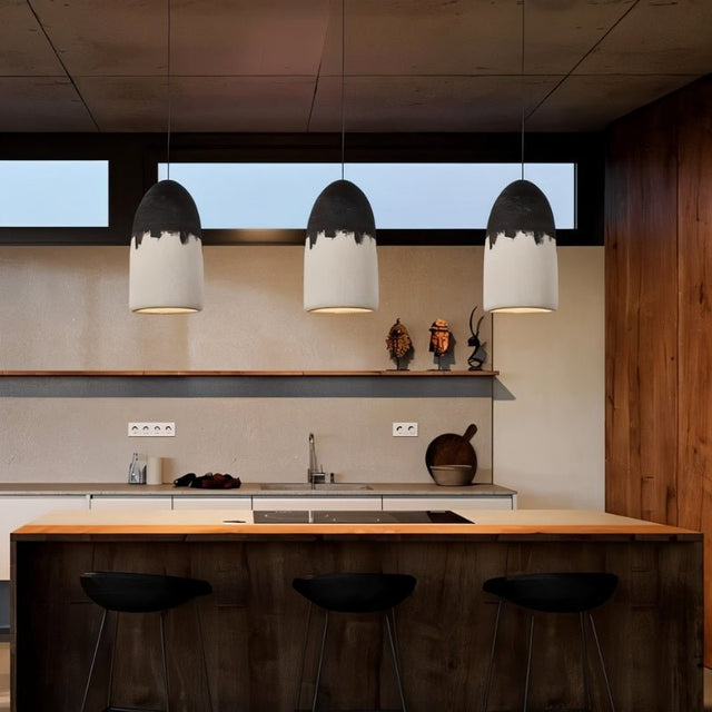 "Pendant lamps with two-tone finish illuminating modern kitchen island"