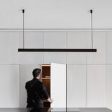 "Ultra-slim aluminum pendant light in minimalist interior, discreet cable suspension, sleek modern lighting"