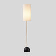 "Isolated view of floor lamp, cylindrical fabric shade, slim wooden pole."