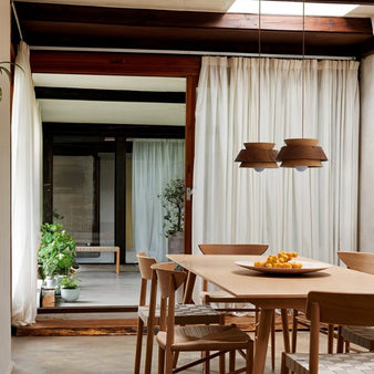 "Wooden pendant light hanging over a dining table, enhancing the natural ambiance in a Scandinavian-inspired space."