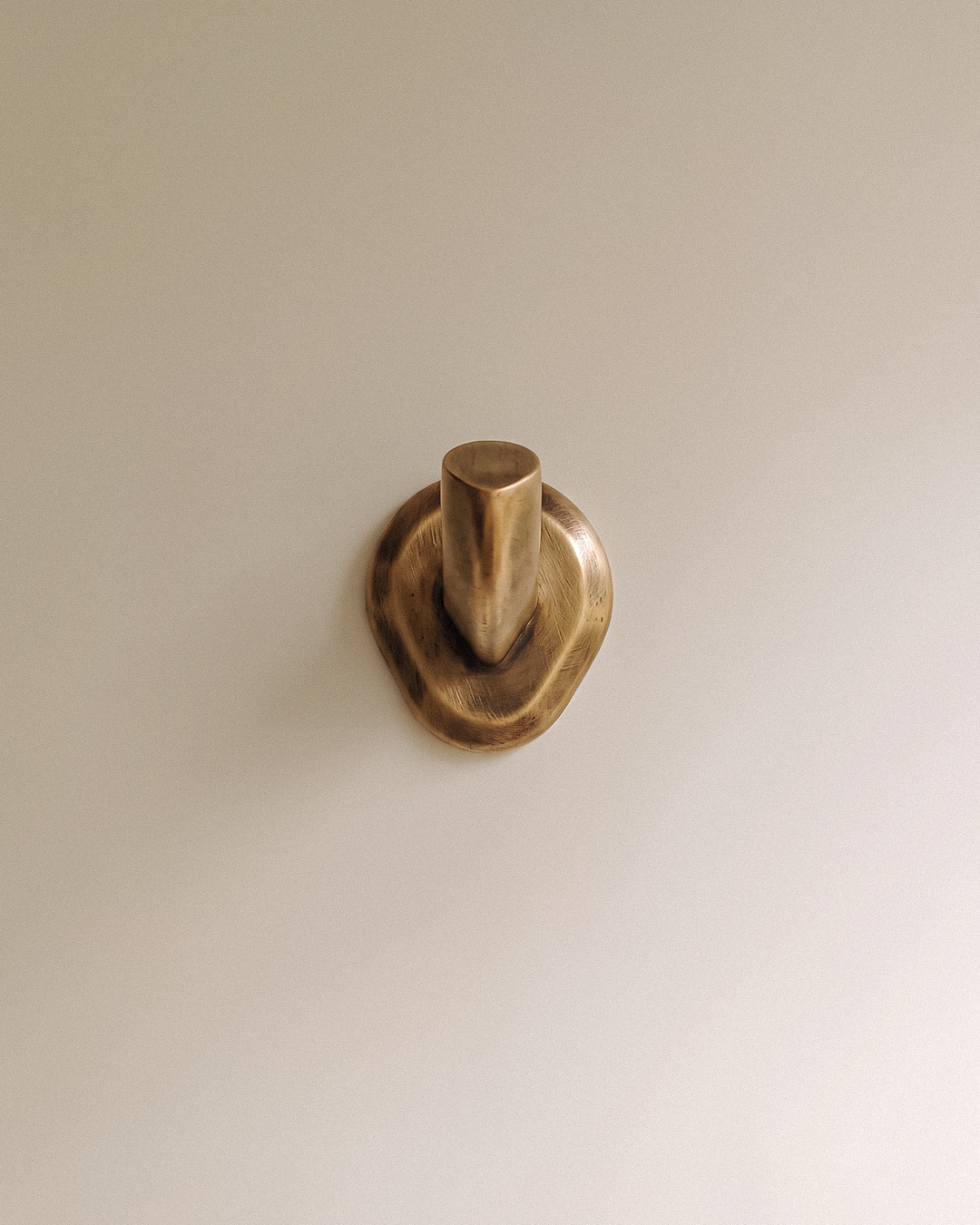 Enzo Wall Hook in Unlacquered Brass front view, on a plain background